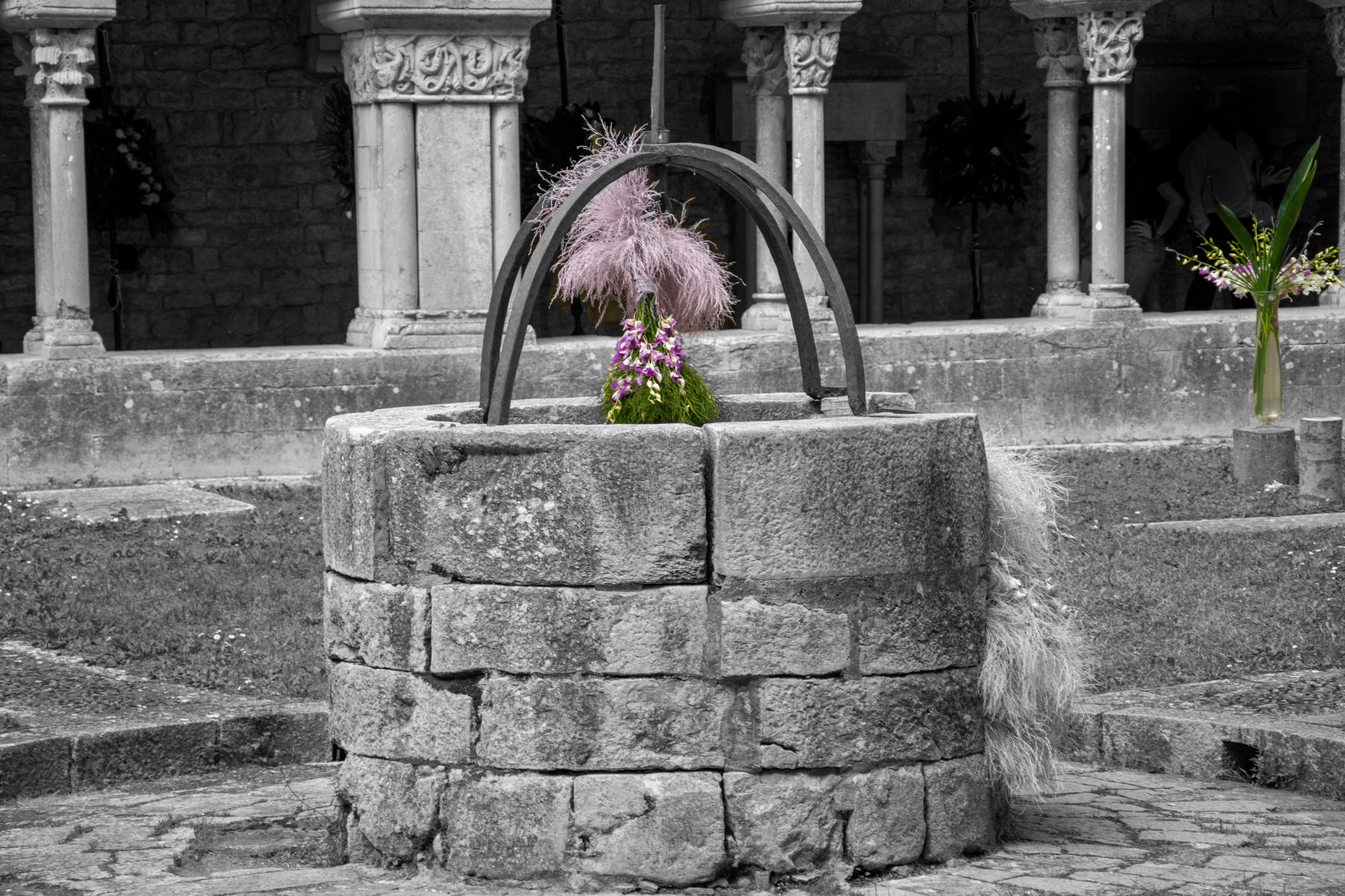 Hier sollten Sie ein Bild mit einem alten Brunnen und einer blühenden Pflanze darin sehen ...